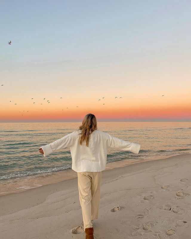 Mujer caminando por la playa frente al mar